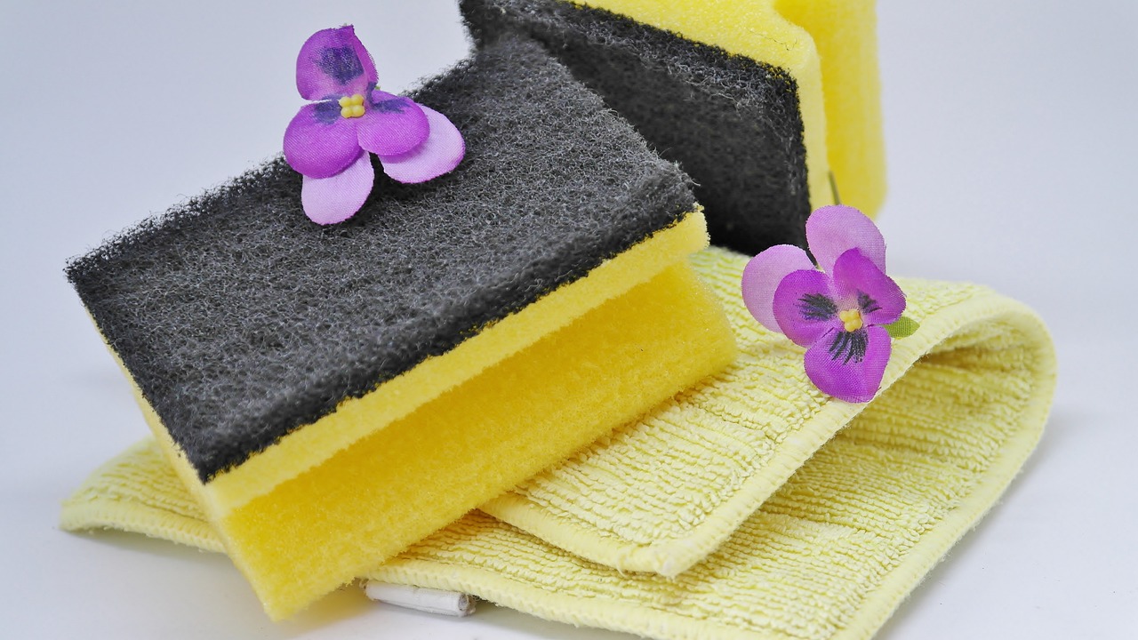 żółta gąbka, żółta ściereczka do sprzątania, fioletowe kwiaty, Pleśń w łazience, usuwanie pleśni w łazience, domowe sposoby usuwania pleśni